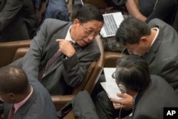 Myanmar Ambassador to the United Nations, Hau Do Suan, left, speaks to members of his delegation during a General Assembly's human rights committee meeting, Nov. 16, 2017 at United Nations headquarters.