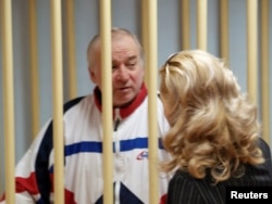 FILE - Sergei Skripal, a former colonel of Russia's GRU military intelligence service, looks on inside the defendants' cage as he attends a hearing at the Moscow military district court, Russia, Aug. 9, 2006.