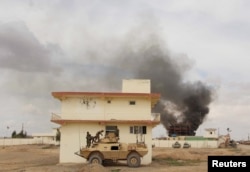 Smoke billows from a building after a Taliban attack in Gereshk district of Helmand province, Afghanistan on March 9, 2016.