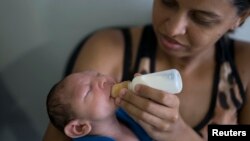 Daniele Ferreira dos Santos feeds her son Juan Pedro, who suffers from microcephaly, as they wait to be examined at the Altino Ventura Foundation, a treatment center that provides free health care, in Recife, Pernambuco state, Brazil, Feb. 4, 2016.