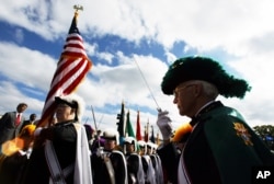 Knights of Columbus Virginia Associate Marshal Richard C. Bowman, right, salutes the U.S. flag during a ceremony celebrating the achievements of explorer Christopher Columbus at the Columbus Park-Union Station, Monday, Oct. 11, 2004, in Washington.