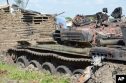 FILE - Tanks sit destroyed after fighting between forces of Salva Kiir and Riek Machar, on July 10, 2016, in Jabel area of Juba, South Sudan.