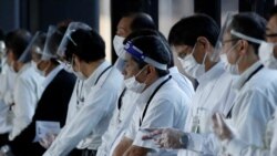 Staffs wearing face shields and masks wait for passengers who need wheelchairs at an arrival gate of Narita international airport on the first day of closed borders to prevent the spread of the new Omicron variant in Narita, east of Tokyo, Japan, Nov. 30, 2021.