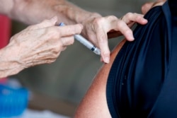 A man receives a COVID-19 vaccine at a clinic at Mother's Brewing Company in Springfield, Mo., on Tuesday, June 22, 2021.(Nathan Papes/The Springfield News-Leader via AP)