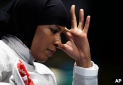 Ibtihaj Muhammad of the United States reacts after losing against Cecilia Berder of France in the women's individual saber fencing event at the 2016 Summer Olympics in Rio de Janeiro, Brazil, Aug. 8, 2016.