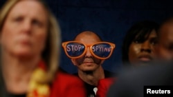 A protester critical of the practices of U.S. security agenices sits in the audience as U.S. top intelligence officials testify on Capitol Hill in Washington, October 29, 2013.