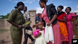 Christian women and children are scanned with a metal detector and have their bags searched to prevent against possible attacks, as they enter the compound of the Our Lady of Consolation Church in Garissa, Kenya, April 5, 2015.
