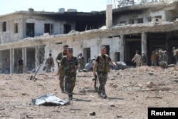 Forces loyal to Syria's President Bashar al-Assad walk at a military complex after they recently recaptured areas in southwestern Aleppo, Syria, in this handout picture provided by SANA on Sept. 5, 2016.