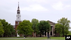 FILE - Students cross The Green in front of the Baker-Berry Library at Dartmouth College in Hanover, N.H.