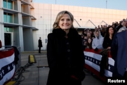 Republican U.S. Senator Cindy Hyde-Smith listens to U.S. President Donald Trump speak on her behalf during a Hyde-Smith campaign rally in Tupelo, Mississippi, Nov. 26, 2018.