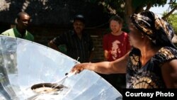 Solar energy champion Crosby Menzies watches a Zambian woman cooking on one of his unique cookers that are powered by the sun (Photo: Sunfire)