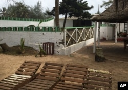 FILE - Bullet holes are seen on a wall, center, outside of the Nouvelle Paillote hotel, one of the three hotels involved in an attack at Grand Bassam, Ivory Coast, March 14, 2016.
