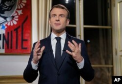 French President Emmanuel Macron, gestures as he poses for a photograph after the recording of his New Year's speech at the Elysee Palace, in Paris, Dec. 31, 2018.