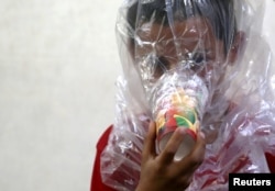 A boy tries on an improvised gas mask in Idlib, Syria, Sept. 3, 2018. The U.S. special adviser for Syria, Jim Jeffrey, said there is evidence that chemical weapons are being prepared by Syrian forces around Idlib.