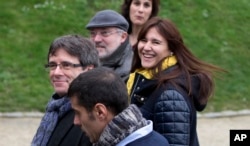 FILE - Ousted Catalan leader Carles Puigdemont, left, walks with elected Catalan lawmakers of his Together for Catalonia party in Brussels, Jan. 12, 2018.