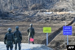 South Korean soldiers stand at Arrowhead Ridge, a site of battles in the 1950-53 Korean War, as a tactical road is built across the military demarcation line inside the Demilitarized Zone (DMZ) in the central section of the inter-Korean border in Cheorwon.