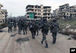 FILE - Syrian government troops and allied militiamen walk inside the key town of Salma in Latakia province, Syria, Jan 12, 2016.