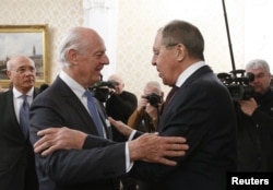 Russian Foreign Minister Sergei Lavrov, right, welcomes U.N. special envoy on Syria Staffan de Mistura during a meeting in Moscow, Nov. 24, 2017.