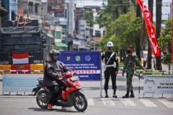 Sejumlah tentara menjaga penyekatan PPKM darurat untuk meredam penyebaran pandemi COVID-19 di Medan, Sumatera Utara, Kamis, 15 Juli 2021. (Foto: Binsar Bakkara/AP)