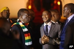 Zimbabwean President Emmerson Mnangagwa, left, arrives at Robert Mugabe International Airport in Harare, Zimbabwe, Monday, Jan. 21, 2019.