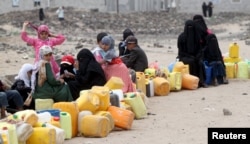 FILE - A five-day humanitarian truce in Yemen appeared to be broadly holding as people wait to collect water from a public tap amidst an acute water shortage, in Sana'a, May 13, 2015.