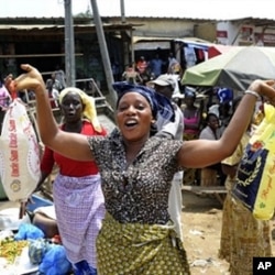 A woman holds bags of rice at a market in Abidjan. Some economists say food scarcity and rising prices could lead to social instability.