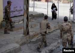 A woman holds her child as she crosses from an Islamic State-controlled part of Mosul into an Iraqi special forces-controlled part of Mosul, Iraq, Nov. 14, 2016.