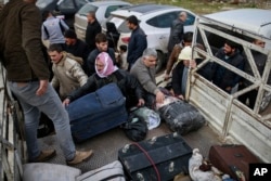 Syrians put their belongings into vehicles after crossing into Turkey at the Cilvegozu border gate with Syria, near Hatay, southeastern Turkey, Dec. 18, 2016.