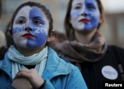 FILE - Natalia Plaza, left, and Suzanne Tufan, with their faces painted, wait for a campaign rally with U.S. Democratic presidential candidate Bernie Sanders in the Greenwich Village neighborhood of New York, April 13, 2016. Many young voters are not displaying this sort of passion in the 2016 presidential campaign.