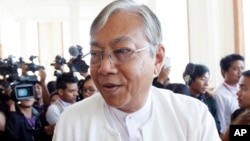 FILE - In this Monday, Feb. 1, 2016, file photo, Htin Kyaw, center, walks in Naypyitaw, Myanmar. A longtime confidant of Aung San Suu Kyi was confirmed Friday, March 11, 2016.