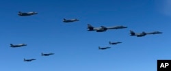 In this photo provided by South Korea Defense Ministry, U.S. Air Force B-1B bombers, F-35B stealth fighter jets and South Korean F-15K fighter jets fly over the Korean Peninsula during a joint drills, South Korea, Sept. 18, 2017.