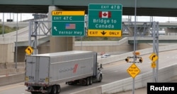 FILE - A commercial truck exits the highway for the Ambassador Bridge to Canada, in Detroit, Michigan, Aug. 30, 2018.