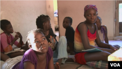 Venise Louis, at far right, joins in watching cartoons at a Haitian orphanage for HIV-positive children.