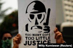 Seorang mahasiswa memegang poster dalam aksi unjuk rasa untuk menentang pelanggaran hak asasi manusia, korupsi dan kasus pencemaran lingkungan di Jakarta pada 28 Oktober 2019. (Foto: Reuters/Willy Kurniawan)