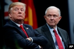 FILE - President Donald Trump sits with Attorney General Jeff Sessions during the FBI National Academy graduation ceremony in Quantico, Virginia.