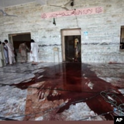 A Pakistani villager sweeps the floor of a mosque targeted by a suicide bomber in Khyber, Aug. 19, 2011.