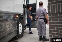 FILE - A shackled migrant woman in federal custody arrives for an immigration hearing at the U.S. federal courthouse in McAllen, Texas, May 20, 2019.
