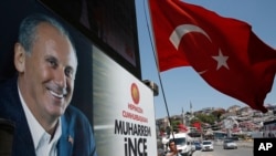 A supporter of Muharrem Ince, pictured left, the presidential candidate of Turkey's main opposition Republican People's Party, waves a Turkish flag prior to one of his rallies, in Istanbul, Turkey, June 16, 2018.