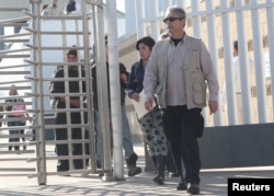 Central American asylum seekers are escorted out of the Chaparral border crossing gate after being sent back to Mexico by the U.S. in Tijuana, Mexico, Jan. 30, 2019.