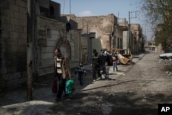 Mustafa Ismael Mustafa flees with his family for the second time during fighting between Iraqi forces and Islamic State militants, on the western side of Mosul, Iraq.