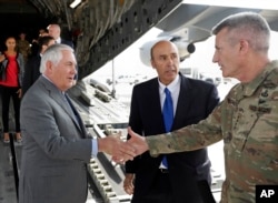 FILE - Secretary of State Rex Tillerson is greeted by Gen. John Nicholson, right, commander of Resolute Support, with Special Charge d'Affaires Amb. Hugo Llorens, as he arrives, Oct. 23, 2017, at Bagram Air Base, Afghanistan.