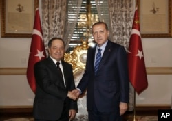 Turkey's President Recep Tayyip Erdogan, right, shakes hands with Iraqi Kurdish leader Massoud Barzani, in Istanbul, Feb. 26, 2017.