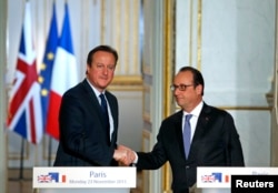 French President Francois Hollande (R) shakes hands with Britain's Prime Minister David Cameron during a joint news conference, Nov. 23, 2015.