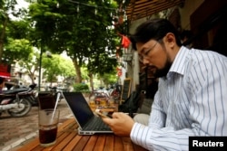 FILE - Vietnamese activist Anh Chi searches the internet at Tu Do (Freedom) cafe in Hanoi, Vietnam August 25, 2017.