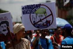 A supporter of Venezuela's President Nicolas Maduro holds a placard depicting U.S. President Donald Trump during a rally in Caracas, Sept. 19, 2017.