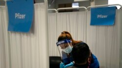 FILE - In this May 21, 2021, photo, licensed vocational nurse Angeline Gabuten administers the Pfizer COVID-19 vaccine to a patient at Providence Edwards Lifesciences vaccination site in Santa Ana, Calif.