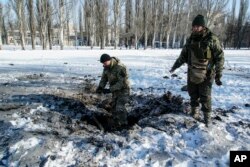 A Ukrainian soldier inspects a crater left by an explosion in Avdiivka, Ukraine, Jan. 31, 2017.