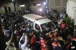 FILE - Volunteers of the Edhi Foundation escort the body of Pakistan's renowned social worker Abdul Sattar Edhi in an ambulance in Karachi, Pakistan, July 8, 2016.