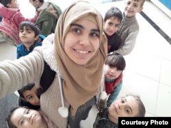 Shahira Qaddour smiles for a picture with the children in Selam Orphanage. (M. Qarra)