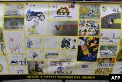 Sebuah gambar yang memamerkan berbagai lukisan yang dibuat anak-anak dari seluruh dunia tampak dekat toko milik pebalap Italia, Valentino Rossi, di kota kelahirannya, Tavulia, 29 Januari 2019.